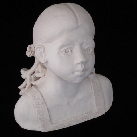 A clay bust of a girl with pigtails.